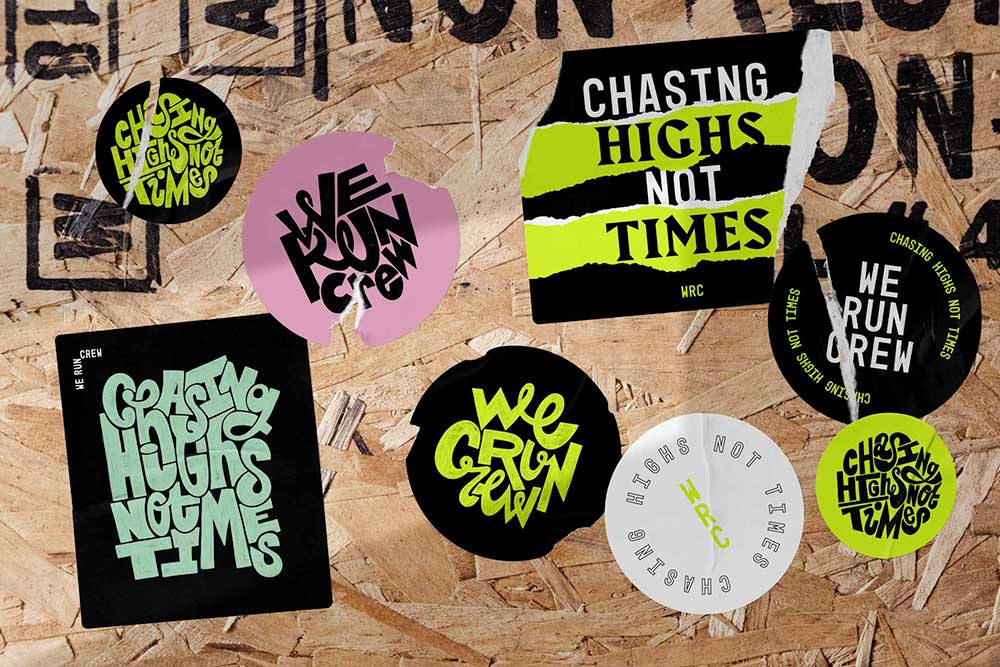 Various stickers featuring We Run Crew branding and hand-drawn typography, stuck to wall